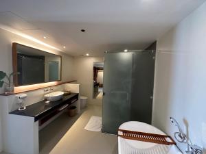 a bathroom with a sink and a glass shower at Bluewater Maribago Beach Resort in Mactan