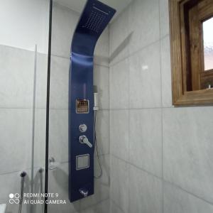 y baño con ducha con cabezal de ducha azul. en Cabañas Mailen'S en Puerto San Julian