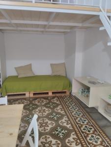 1 dormitorio con 1 cama verde y 1 alfombra en Casa Vacanze Le Doi Salentine, en Parabita