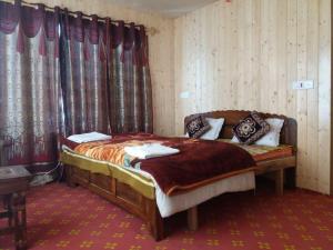 a bedroom with a bed in a room with curtains at Hotel Gulfam Palace in Pahalgām