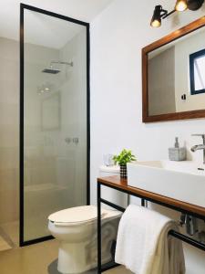 a bathroom with a toilet and a sink and a mirror at Urban Gran Plaza in Guadalajara +39 photos