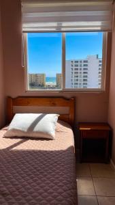 1 dormitorio con cama y ventana con vistas en Departamentos Heimat 3 en La Serena