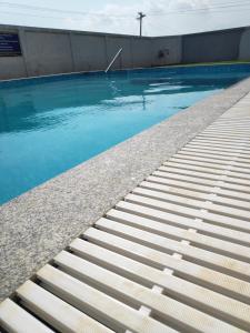 a swimming pool with blue water next to a building at Alegria Resort and SPA, Kovalam in Tirupporūr