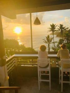two people sitting in chairs looking out at the ocean at The Reef Weligama in Weligama +67 photos