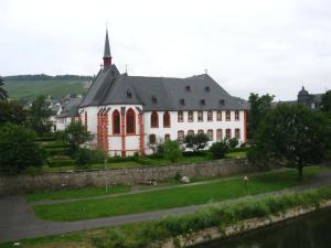Un gran edificio blanco con un campanario en la parte superior. en Ferienwohnungen Eckstein, en Bernkastel-Kues