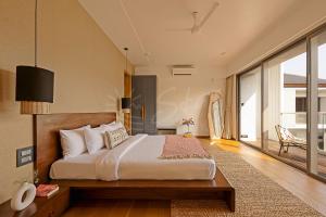 a bedroom with a large bed and a large window at The Banyan Tree Villa A4 by Stay ALYF, Siolim in Siolim