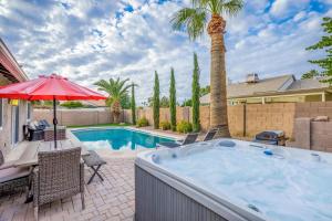 a hot tub in a patio with a table and umbrella at Scottsdale Vacation Rentals in Scottsdale