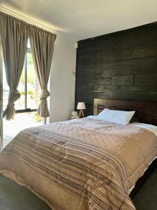 een slaapkamer met een groot bed met een groot houten hoofdeinde bij Tranquil home in hills with city views 