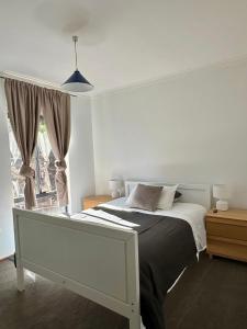 een slaapkamer met een bed en een raam bij Tranquil home in hills with city views 