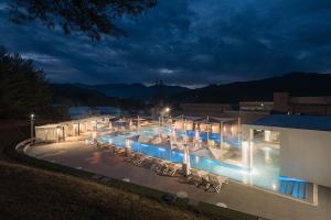 a swimming pool with chairs and lights at night at The Suites Hotel Namwon in Namwon