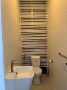 ein Badezimmer mit einem weißen WC und einem Waschbecken in der Unterkunft Sand Castle Villa - Classic Beachfont Luxury 