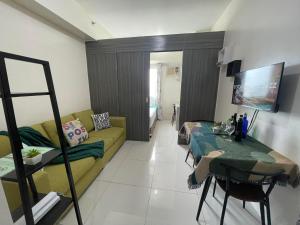 un soggiorno con divano e tavolo di Green Residences Stays by PBYY a Manila