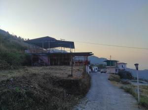 un edificio su una collina vicino a una strada di Sun inn Homestay by StayApart a Mussoorie