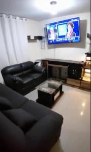 uma sala de estar com um sofá e uma televisão de ecrã plano em Mini departamento lujo em Lima