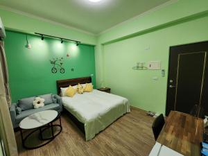台東市的住宿－別有洞天包棟電梯民宿，绿色卧室配有床和椅子