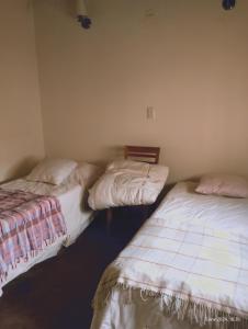 two beds sitting next to each other in a room at Casa en el centro in Río Grande