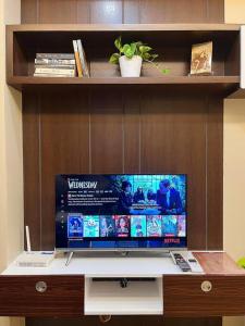 a flat screen tv sitting on top of a desk at Stylish Iloilo condo w/ Netflix and pool access in Iloilo City