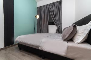 a bedroom with a bed with white sheets and pillows at Mosaic Southkey Marine Blue 2BR by Our Stay in Johor Bahru