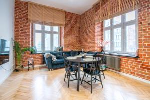 a living room with a brick wall and a table and chairs at Komfortowy loft w centrum ~ Self Check-In 24h in Wrocław