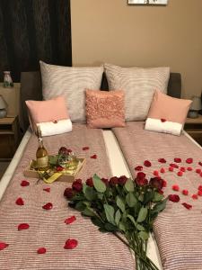 Una cama con un montón de rosas rojas. en Aranyfürt Vendégház en Tokaj