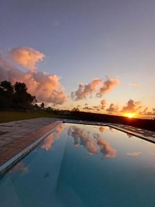 a reflection of the sky in a pool at sunset at Fire Fly Cabin in Knysna