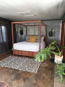 a bedroom with a bed with a wooden frame at Fire Fly Cabin in Knysna