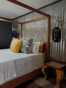 a bed with pillows and a table in a room at Fire Fly Cabin in Knysna