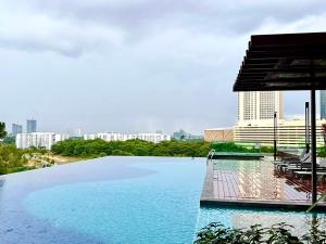 a large swimming pool with a city in the background at Mosaic Southkey Marine Blue 2BR by Our Stay in Johor Bahru