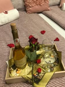 eine Flasche Wein und ein Glas auf dem Bett in der Unterkunft Aranyfürt Vendégház in Tokaj