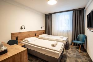 a hospital room with two beds and a chair at Pirat Hotel & SPA-hotel z basenem in Olsztyn