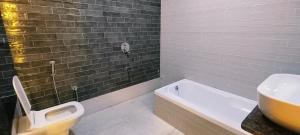 a bathroom with a sink and a toilet and a tub at Hotel Krish villa in Vadodara +60 photos