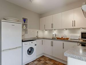 a kitchen with white cabinets and a washer and dryer at 1 Bed in Brixham BX044 in Brixham