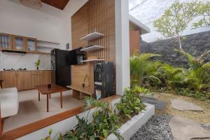a living room with a table and a television in a house at Lodji Ubud in Ubud