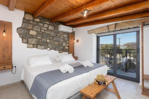 a bedroom with a large bed with towels on it at La Casa Di Pietre 2 in Kiotari +18 photos