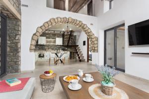 a living room with an archway and a table at La Casa Di Pietre 2 in Kiotari