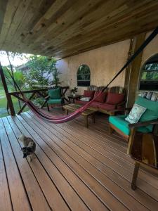 a hammock on a wooden deck with a bird on the floor at Becks Bed & Breakfast in Crooked Tree
