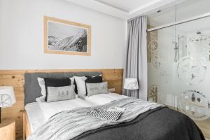 - une chambre avec un lit et un mur en verre dans l'établissement Villa 11 Folk & Design, à Zakopane