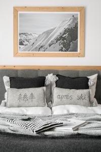 uma cama com duas almofadas e uma fotografia na parede em Villa 11 Folk & Design em Zakopane