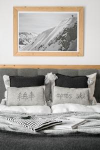 - un lit avec deux oreillers et une photo sur le mur dans l'établissement Villa 11 Folk & Design, à Zakopane