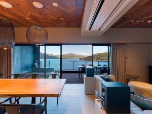 a living room with a view of the water at Rakuten STAY FUJIMI TERRACE 箱根芦ノ湖　 in Moto-hakone