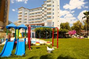 einen Park mit Spielplatzausrüstung vor einem Gebäude in der Unterkunft Nagidos Hotel in Bozyazı