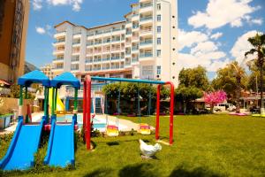 a park with playground equipment in front of a building at Nagidos Hotel in Bozyazı