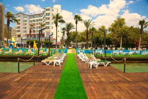 a row of chairs on a boardwalk next to a pool at Nagidos Hotel in Bozyazı
