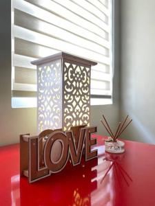una candela e un segno d'amore su un tavolo rosso di Richwell de Maison at Pontefino Prime Elite a Città di Batangas