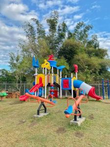 un parco giochi con diverse attrezzature da gioco colorate in un campo di Richwell de Maison at Pontefino Prime Elite a Città di Batangas