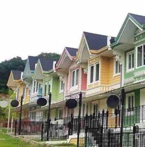 una fila di case colorate con una recinzione di Richwell de Maison at Pontefino Prime Elite a Città di Batangas