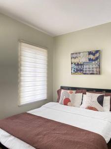 Un pat sau paturi într-o cameră la Richwell de Maison at Pontefino Prime Elite