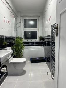 a bathroom with a tub and a toilet and a sink at *Luxury 9ine Lush Jacuzzi Apartment & Balcony* in Birmingham