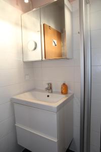 een witte badkamer met een wastafel en een spiegel bij Nimo III in Norddeich