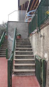 a set of stairs with green railing next to a building at Tigullio Vacations in Leivi